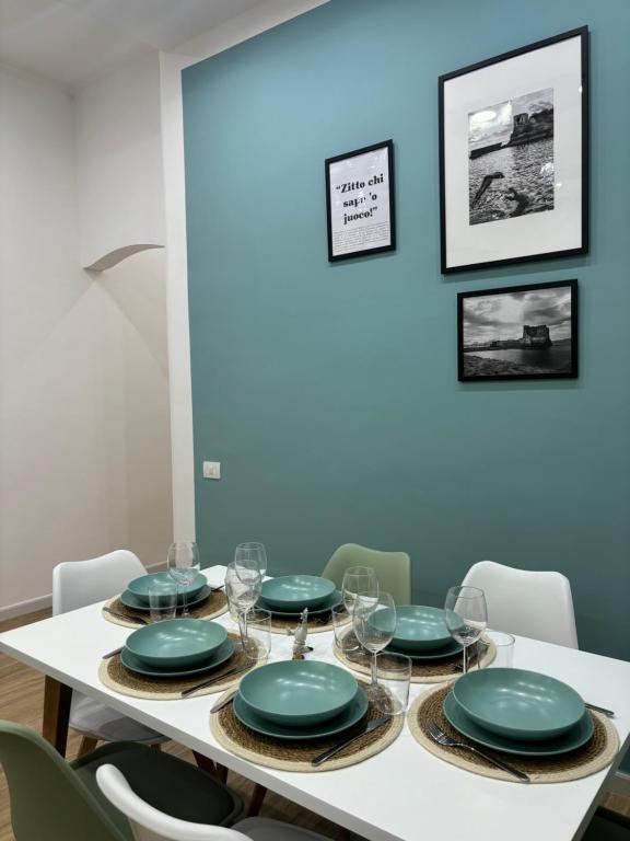 uma sala de jantar com uma mesa com placas verdes em Salotto Mariella em Nápoles