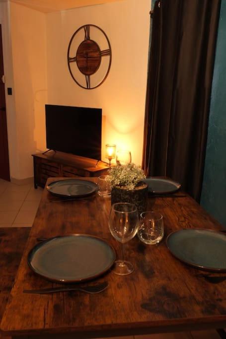 a wooden table with plates and wine glasses on it at Appartement centre ville de Pierrelatte&#39; in Pierrelatte