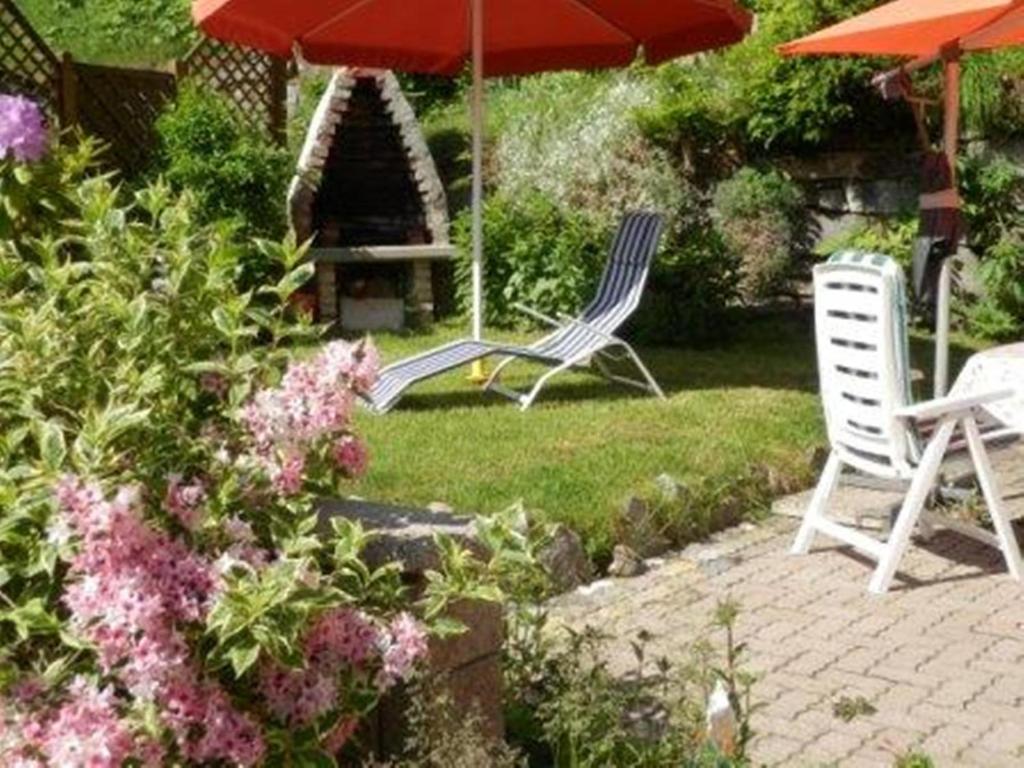 two lawn chairs and an umbrella in a garden at Haus Machreich in Bad Gastein