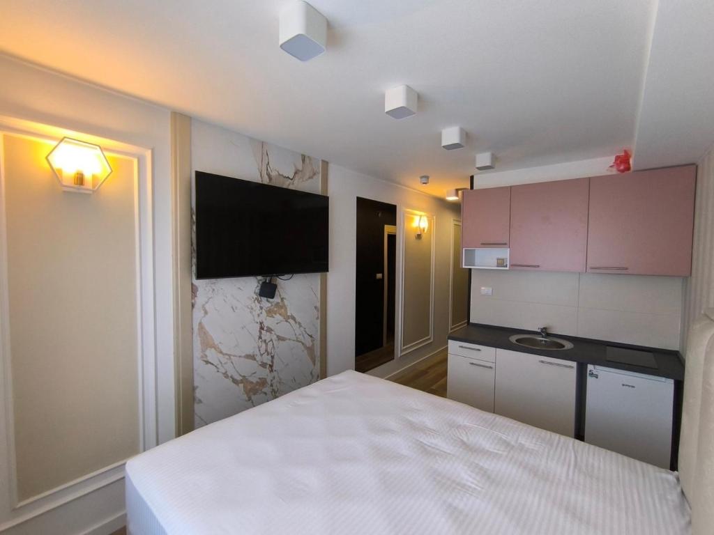um quarto com uma cama branca e um lavatório em Spa Tesla 1 em Batajnica