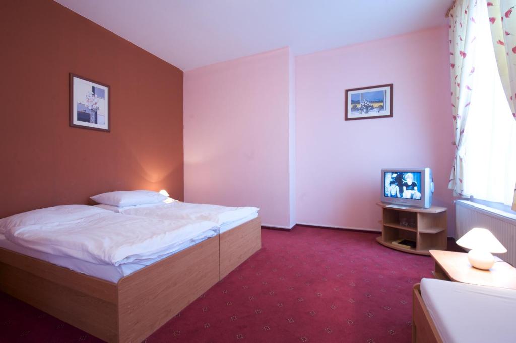 A bed or beds in a room at Hotel Roháč