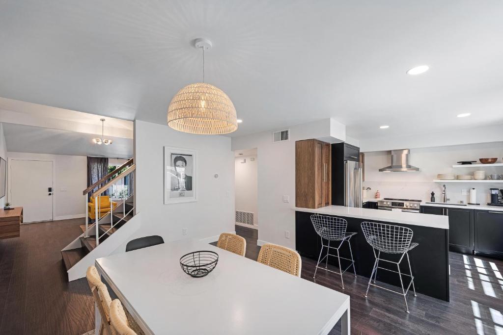 a kitchen and dining room with a white table and chairs at \\Golf and Couples Oasis// Midcentury w/6 Pools Hot Tub in Palm Springs