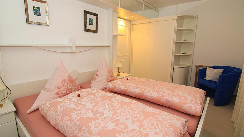 Habitación con cama con almohadas rosas. en Ferienwohnungen Marianne Hölzl, en Schönau am Königssee