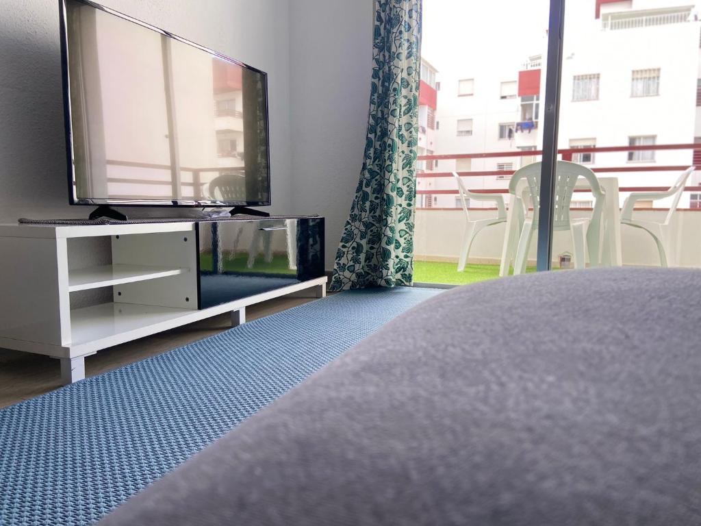 a bedroom with a flat screen tv and a bed at Apartamento de 3 hab en Costa Adeje centro in Adeje