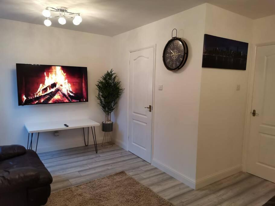 a living room with a fire painting on the wall at Newly Renovated Cosy 1 bed flat, 4 minutes walk to Town Centre, 3 minutes walk to the train station, Free parking, Modern, fresh and spacious living room, Netflix ready smart TV, Wifi in Wellingborough