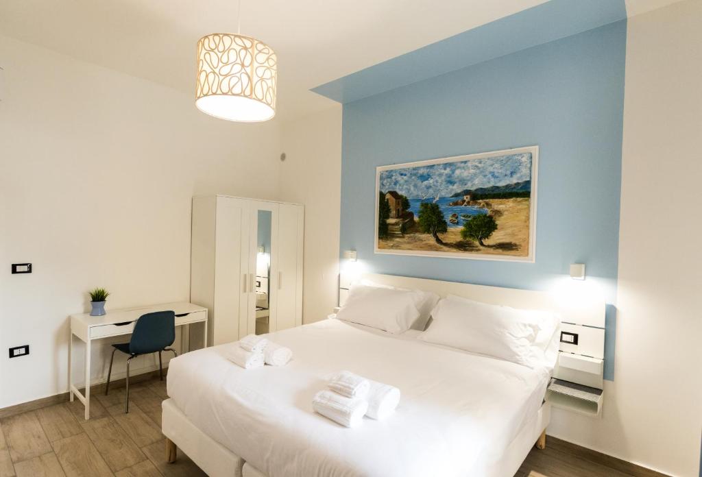 Schlafzimmer mit einem großen weißen Bett und einem Schreibtisch in der Unterkunft Borgo Sant'Angelo Apartment in Rossano
