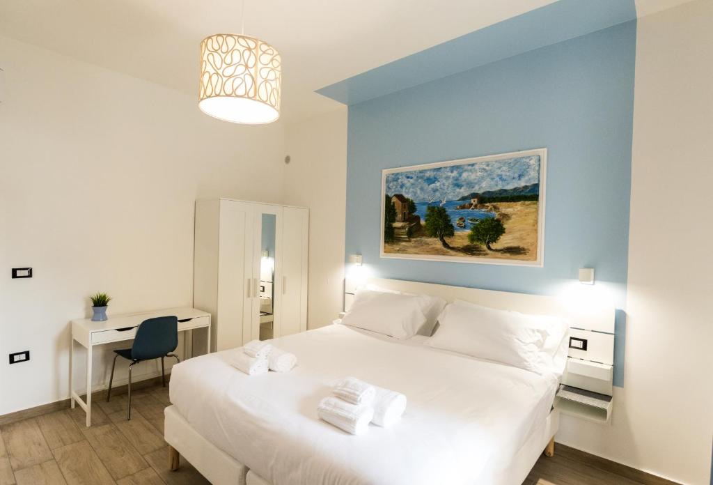 ロッサーノにあるBorgo Sant'Angelo Apartmentの大きな白いベッドと机のある寝室