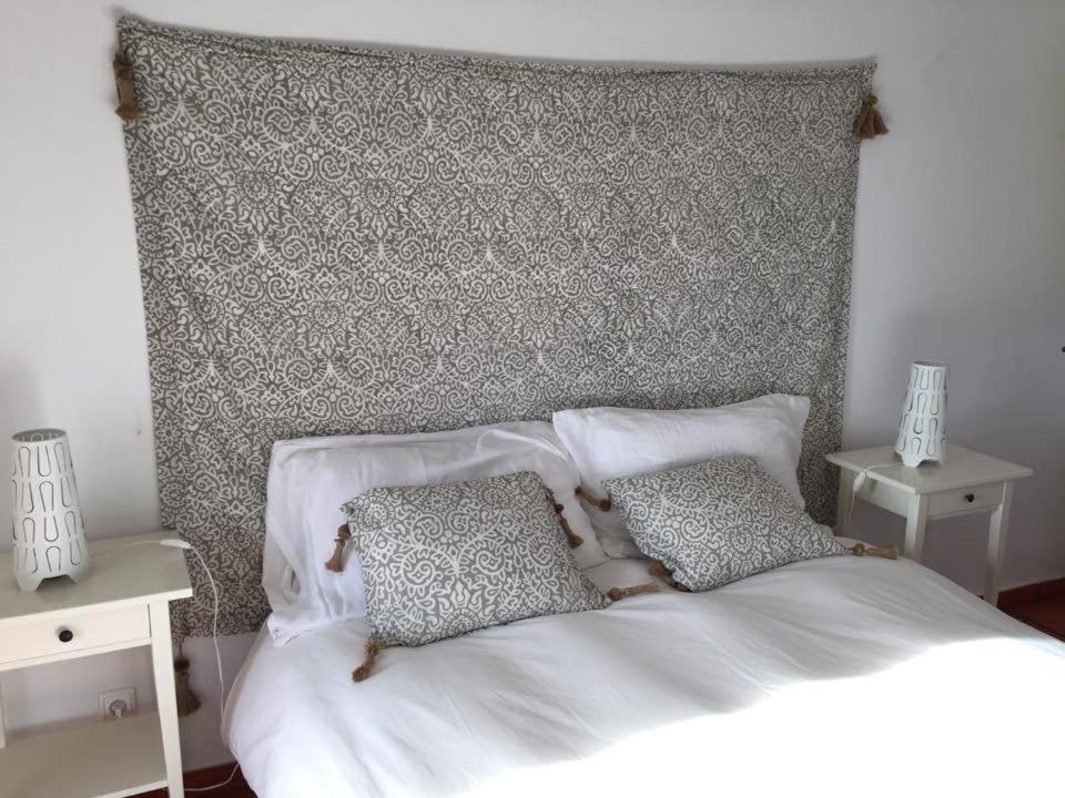 a white bed with two pillows on top of it at Comporta House in Comporta