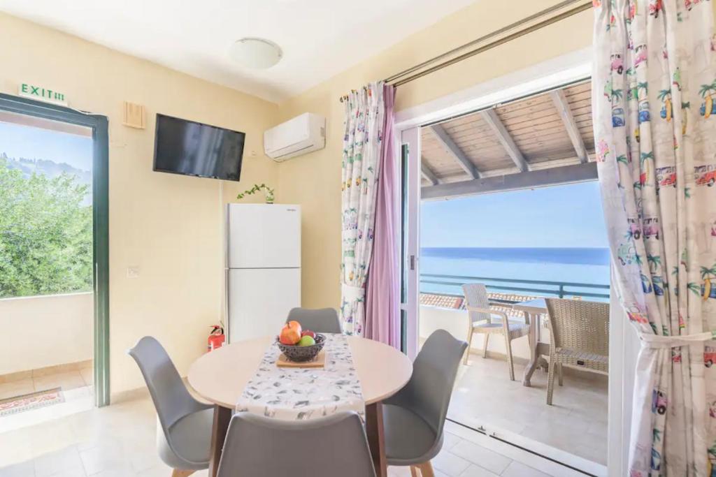 a dining room with a table and chairs and a view of the ocean at Amazing Sea View Balcony Ginos Home 123 in Glyfada