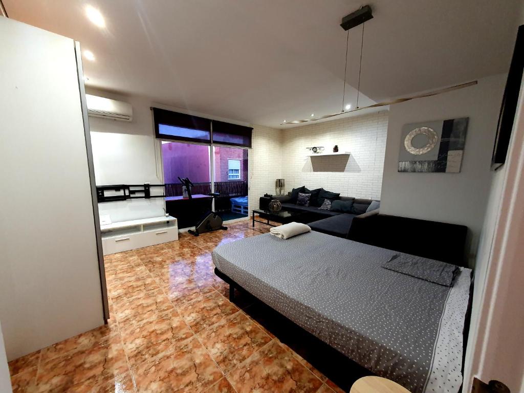 a bedroom with a bed and a living room at Albufera Rooms in Valencia