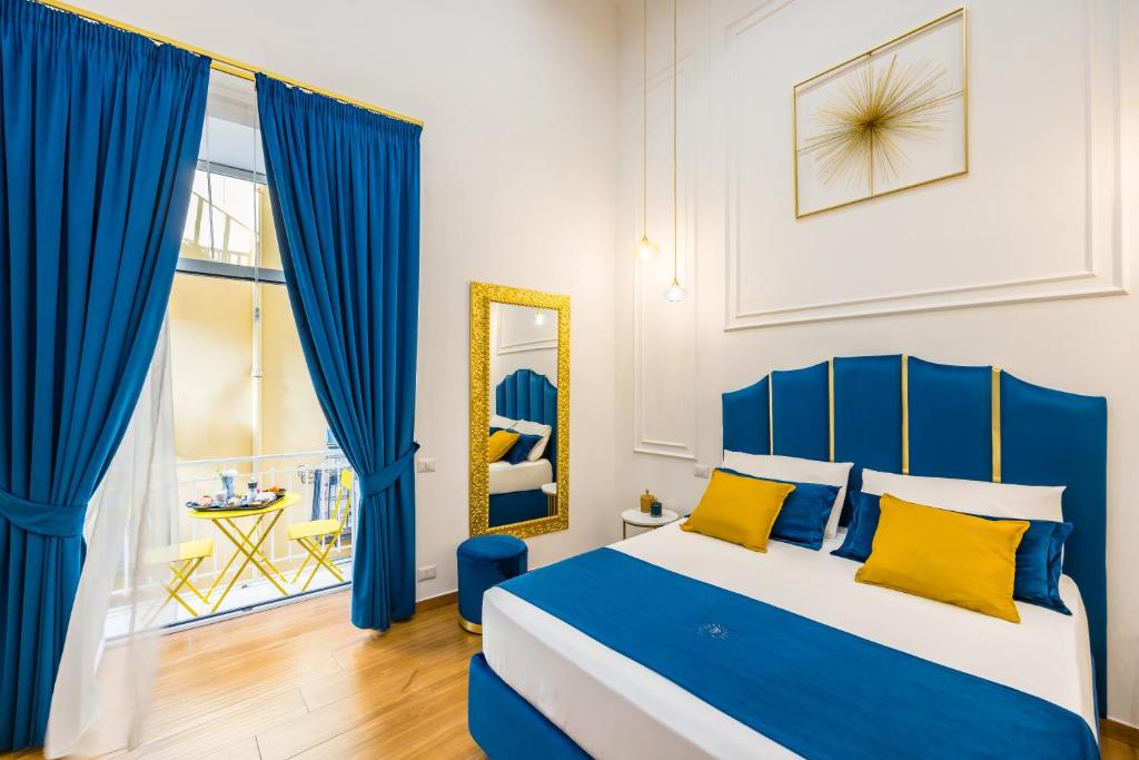 niebiesko-biała sypialnia z łóżkiem i lustrem w obiekcie L'Angolo d'o core w mieście Napoli