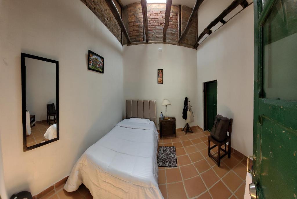 1 dormitorio con 1 cama en una habitación con espejo en CASA DE LOURDES - LA CANDELARIA, en Bogotá