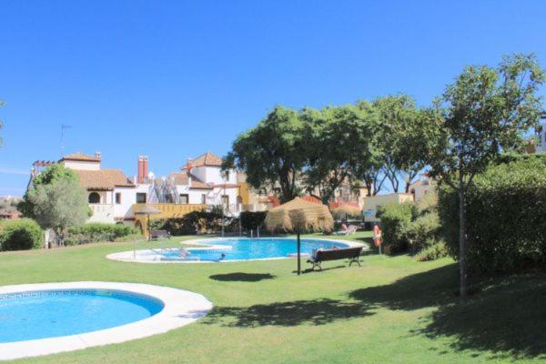 uma piscina com um banco num quintal em ACOGEDOR ADOSADO DE ESQUINA. LAS LOMAS. JUNTO AL ALGARVE PORTUGUÉS. em Huelva