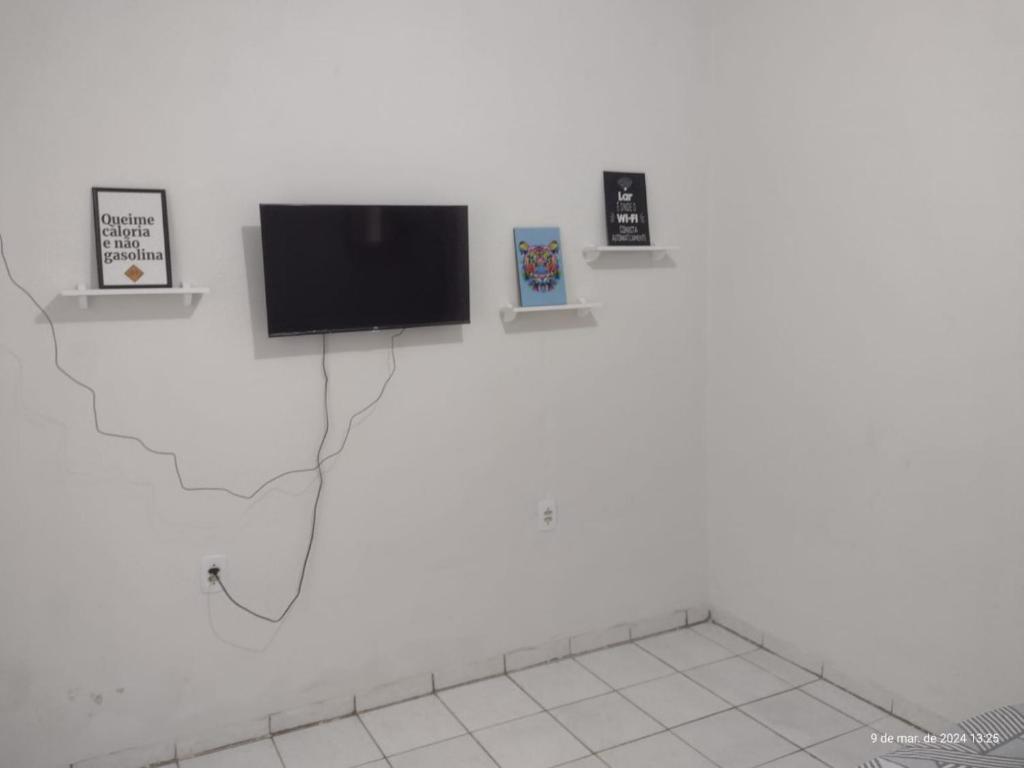 uma televisão de ecrã plano numa parede branca em Cozy em Palmas