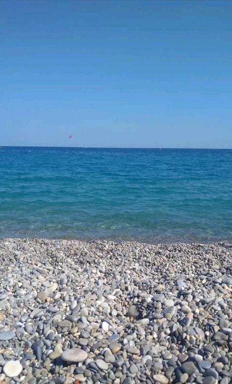 une plage rocheuse avec l'océan en arrière-plan dans l'établissement Logement entier - Les Baumettes, à Nice