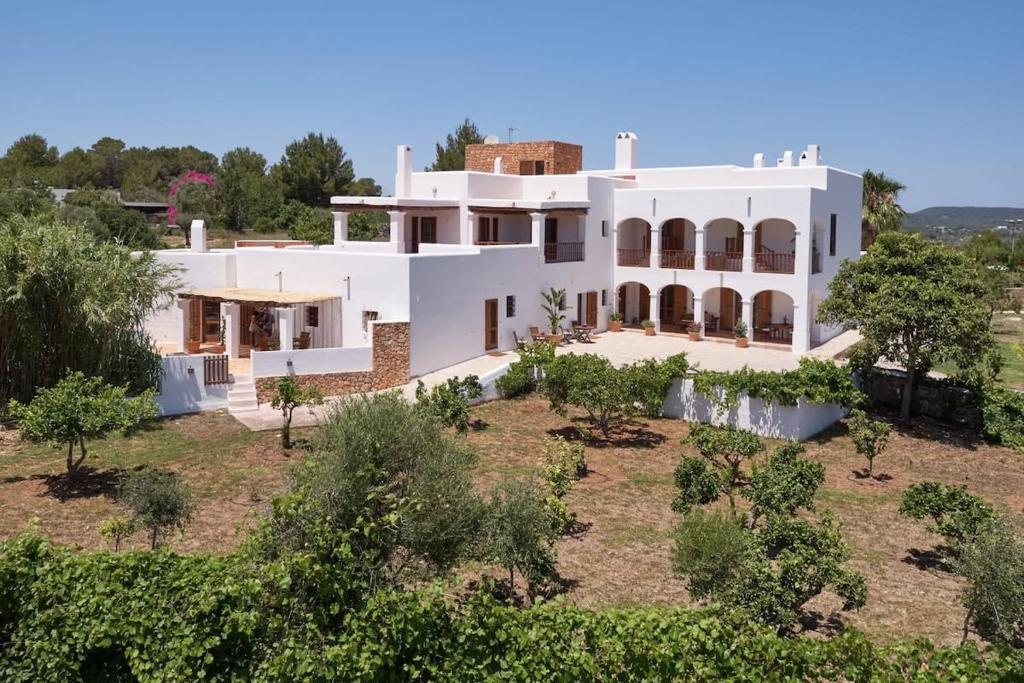 una vista aérea de una casa blanca con árboles en Private Family Size Villa in Nature with Tennis, Basketball and Football Courts for Holidays and Retreats, en Sant Rafel de sa Creu