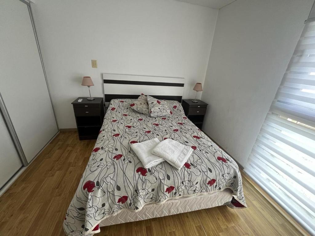 um quarto com uma cama com duas mesas de cabeceira e duas janelas em Alameda Departamento Temporario em Santa Fé