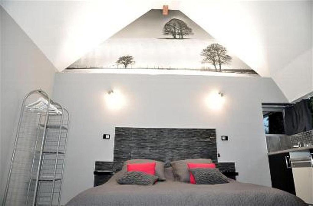 a bedroom with a bed with two trees on the wall at studio mil roses in Andé