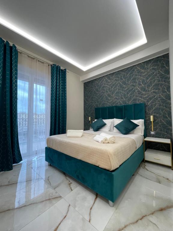 a bedroom with a large bed and a large window at Napoli Central Suites in Naples