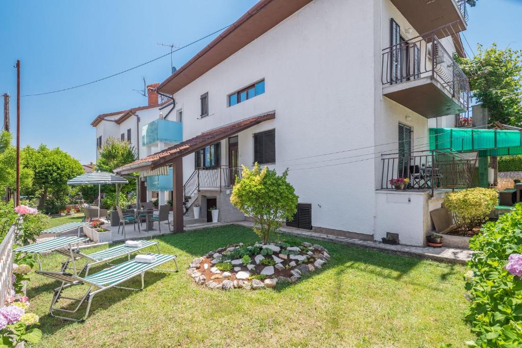 an apartment with a garden with benches and tables at Apartments Katana in Poreč