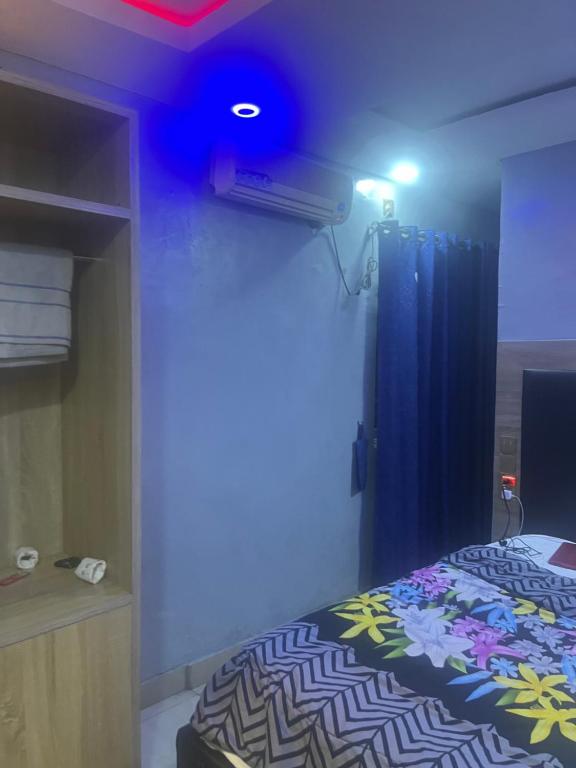 ein Schlafzimmer mit einem Bett und einem blauen Licht in der Unterkunft EXCLUSIVE MANSION HOTELS in Lagos