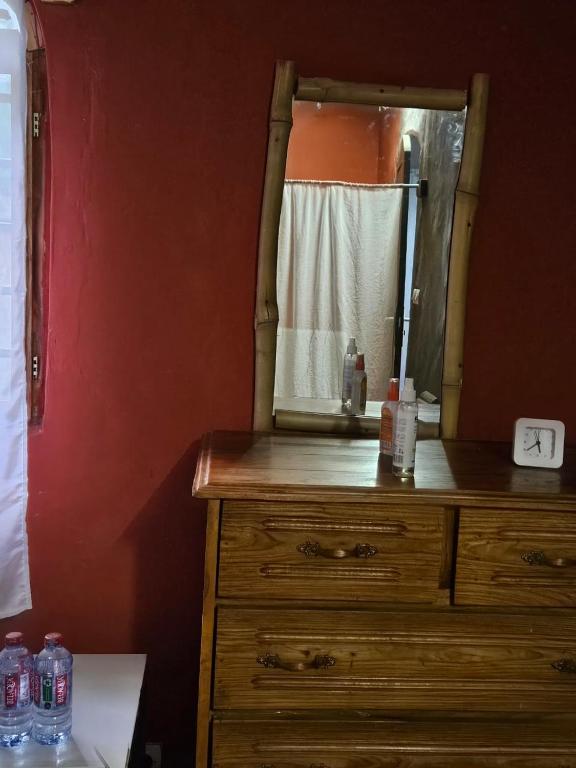 ein Badezimmer mit einer Holzkommode und einem Spiegel in der Unterkunft YAA HOMÉ in Palimé