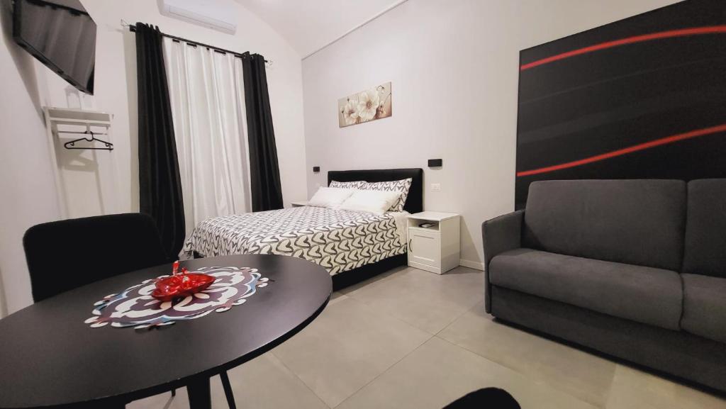 Habitación con cama, mesa y sofá en Giglio Rosso, en Bari