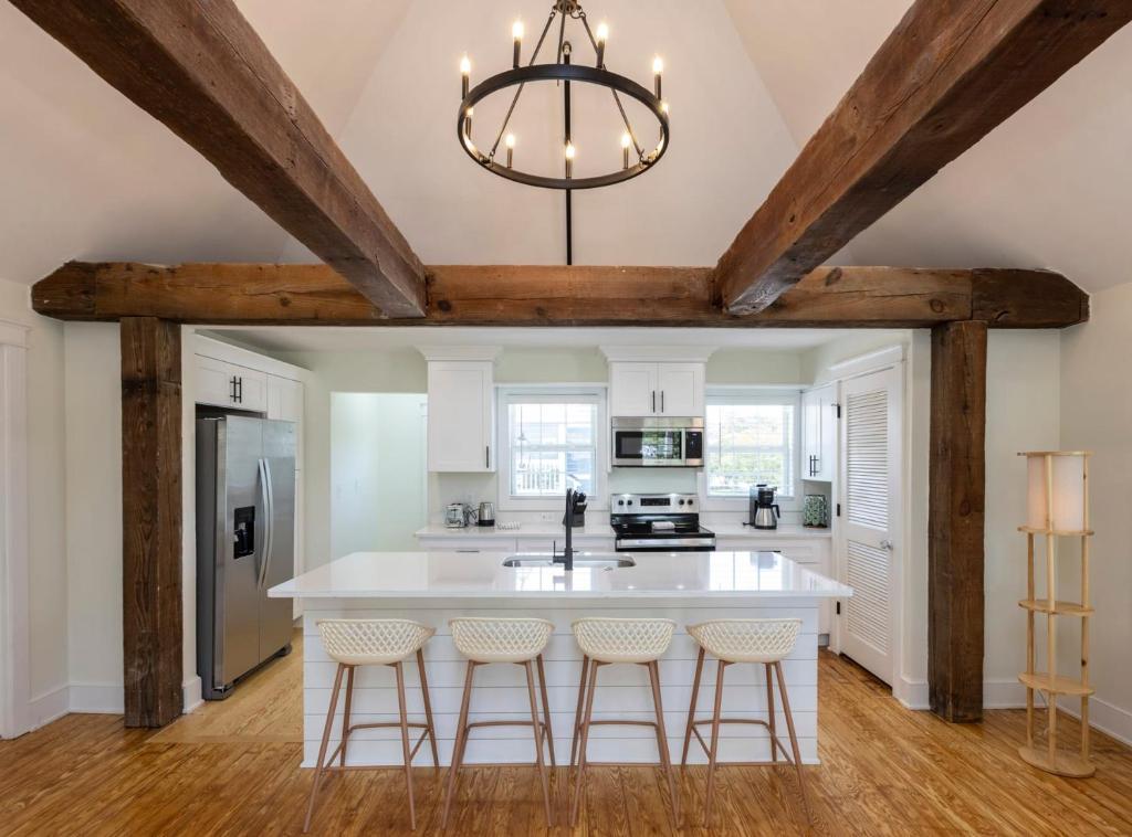 a kitchen with a large white island with bar stools at Cape Henry House Inn at Old Beach in Virginia Beach