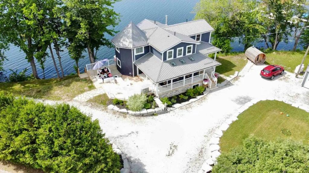 an aerial view of a house with a car in front of it at Waterfront Cottage w Sauna on Sharbot Lake in Sharbot Lake