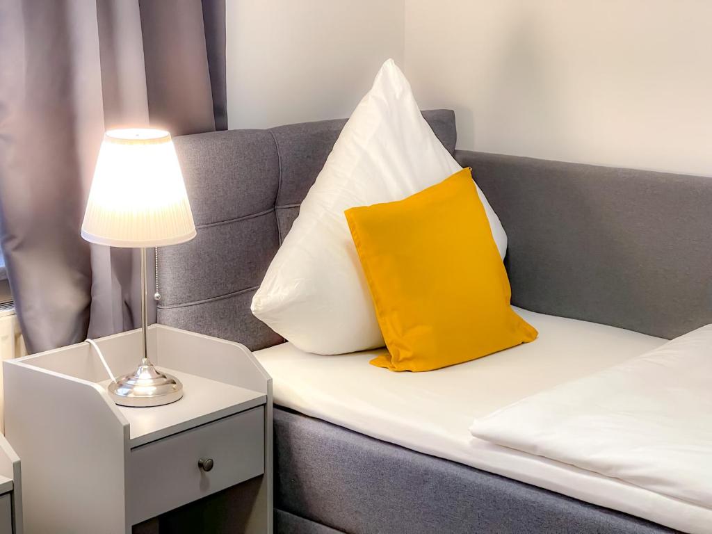 Una cama con una almohada amarilla y blanca. en Eddy´s Appartment en Magdeburgo