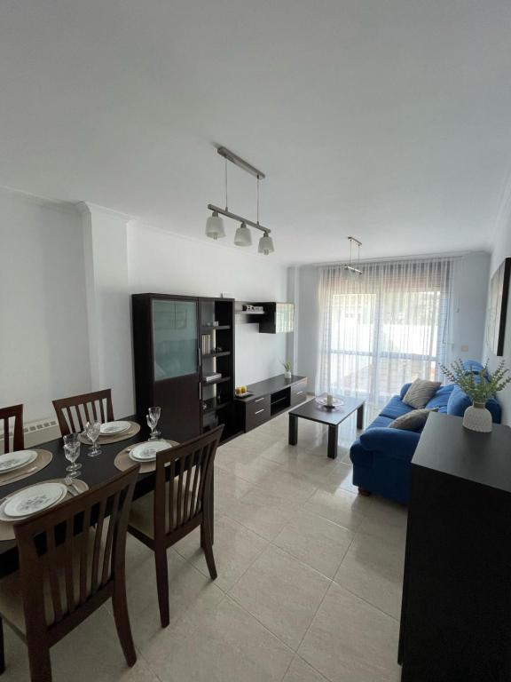 uma sala de estar com uma mesa e um sofá azul em Apartamento Hío Aldán - Cangas em Vilariño