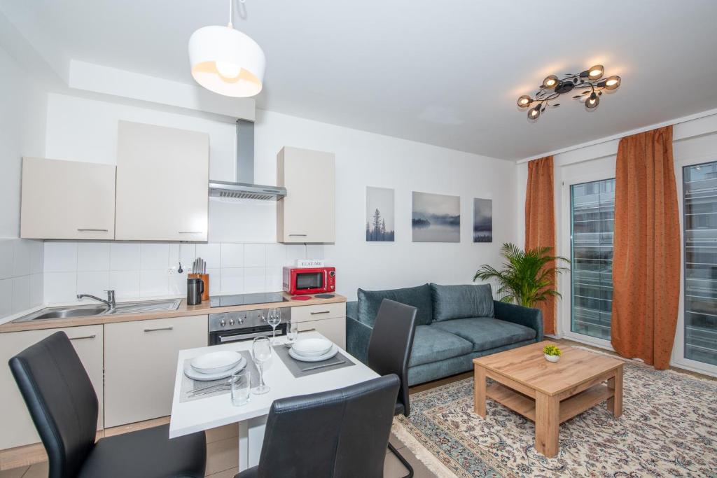 eine Küche und ein Wohnzimmer mit einem Sofa und einem Tisch in der Unterkunft Lipi Apartment in Wien