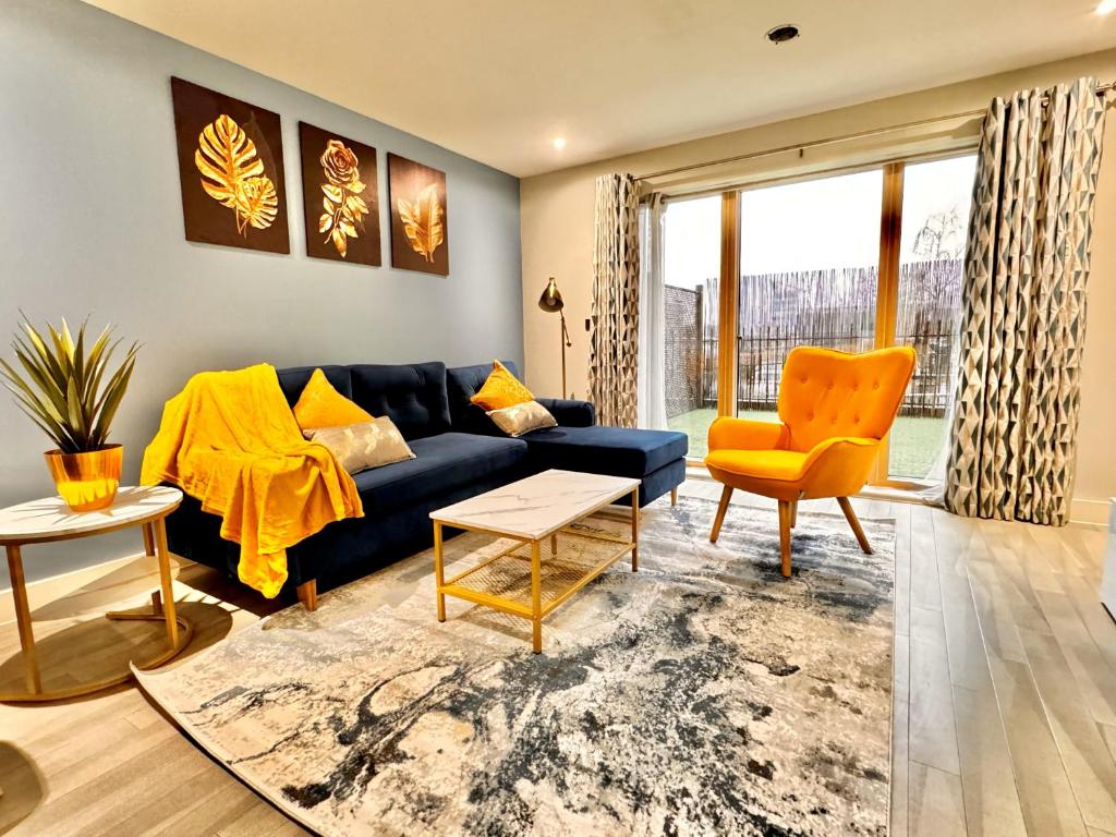 a living room with a blue couch and a yellow chair at Bright & Spacious-Secured flat near slough station in Slough