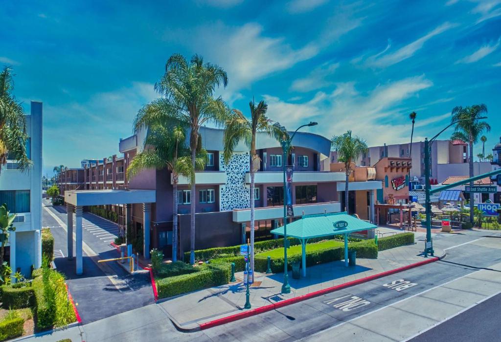un edificio de apartamentos con palmeras y un parque infantil en Best Western Plus Park Place Inn - Mini Suites, en Anaheim