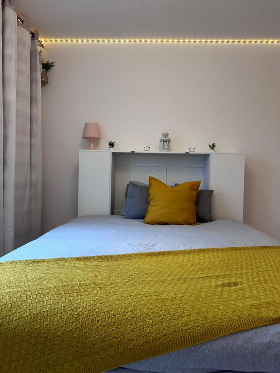 1 dormitorio con 1 cama grande con almohadas amarillas en Come n Go - Homestay en Birmingham