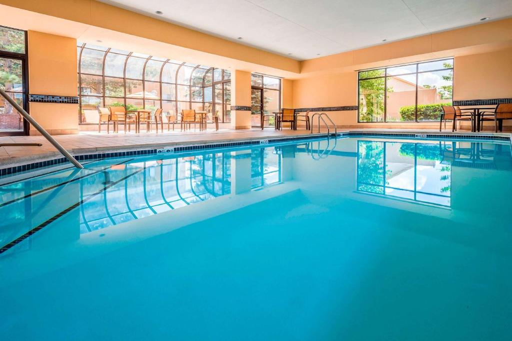 a swimming pool with blue water in a building at Sonesta Select Boston Milford in Milford