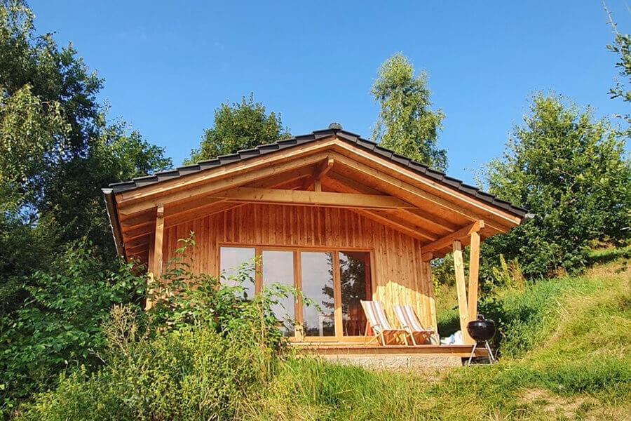 a small cabin with two chairs on a hill at Berg-Chalet im Glamping-Paradies auf dem Dengler Hof in Hohenberg an der Eger