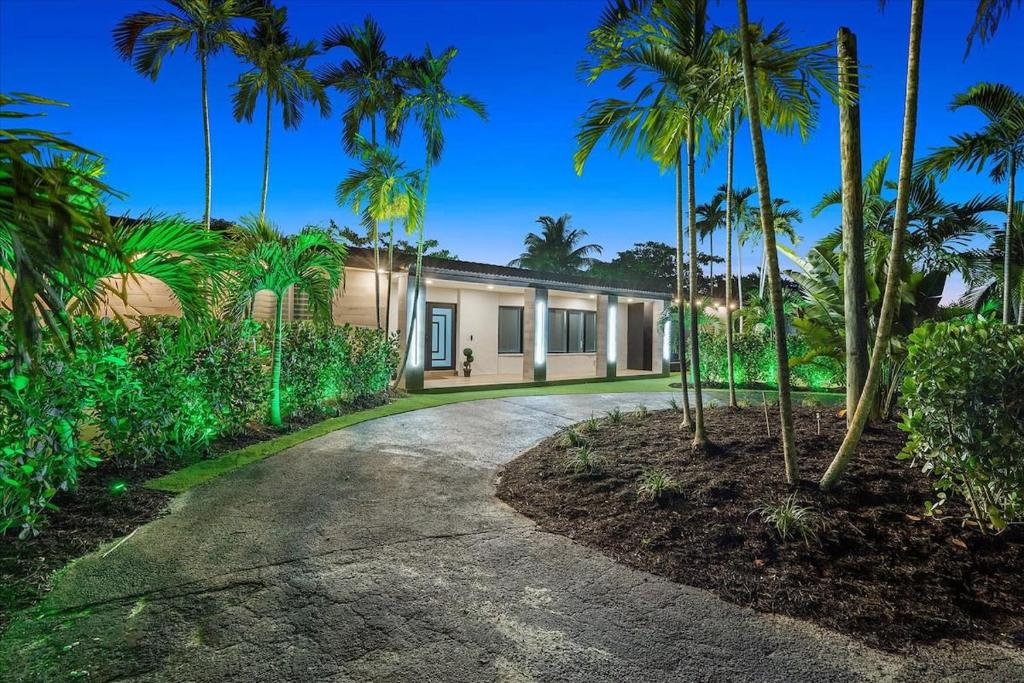 a home with palm trees in front of a driveway at VillaKOBO Heated pool Spa Golf Tennis crocodile in Miami
