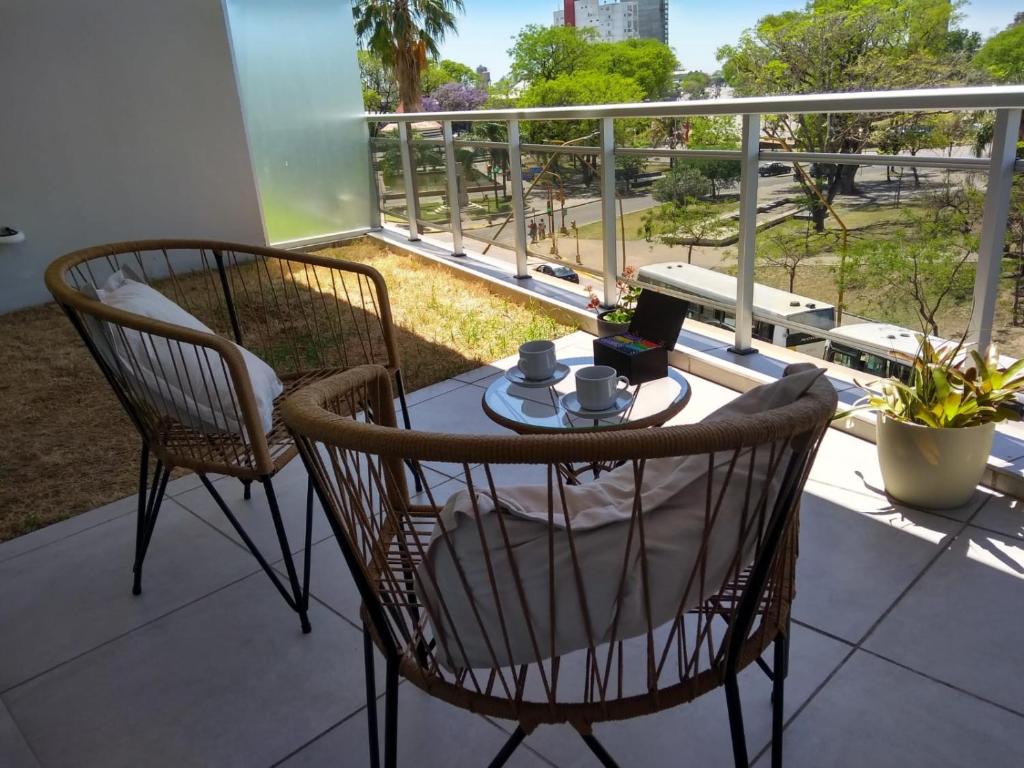 Un balcón con 2 sillas y una mesa con tazas de café. en Dpto Alberdi en Santa Fe