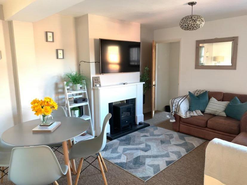 a living room with a table and a fireplace at ⭐️Sleeps 4/Longstays/Garden/Parking/WiFi⭐️ in Crawley