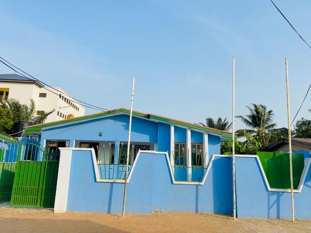 una casa azul con una valla delante de ella en Heavens Gate, en Accra