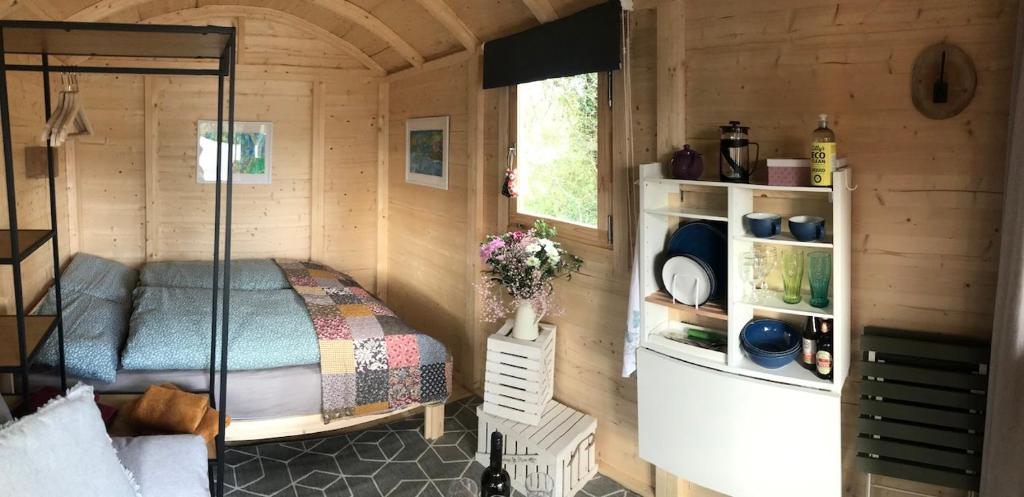 um quarto com uma cama num chalé de madeira em Cosy Shepherds hut Between Maple and Hawthorn em Mountshannon