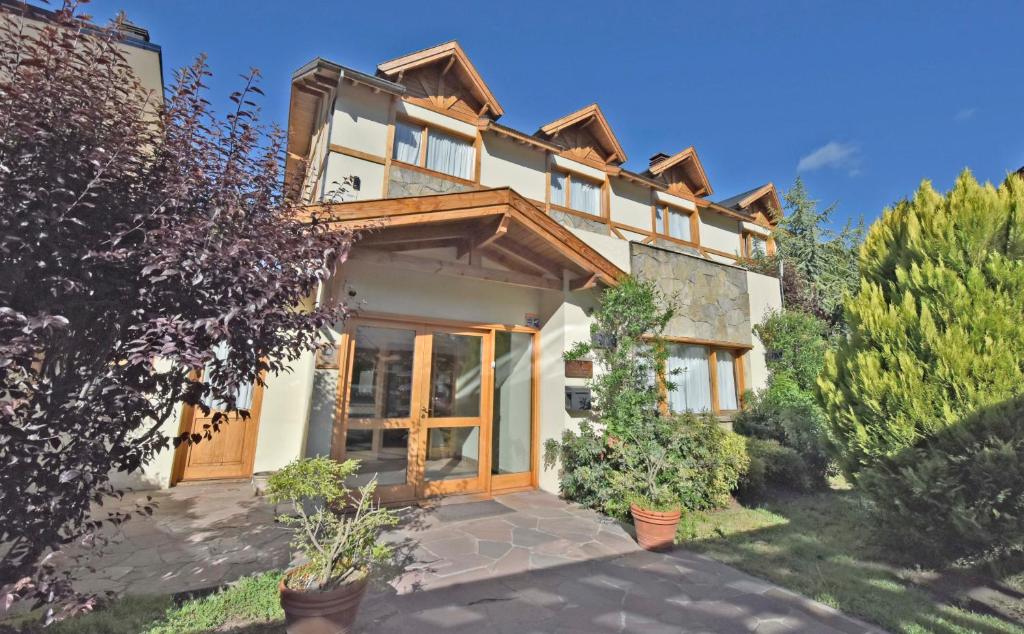 a large house with wooden doors and plants at Hosteria Monteverde in San Martín de los Andes