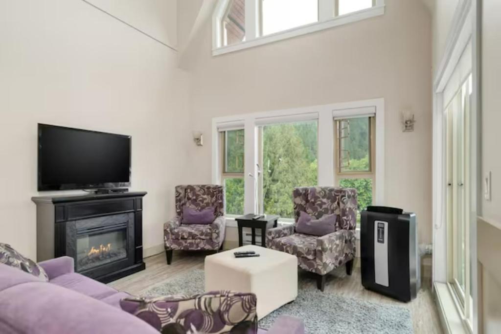 a living room with a couch and chairs and a fireplace at Harrison Lake Pets Welcome-3BR Penthouse Suite in Harrison Hot Springs