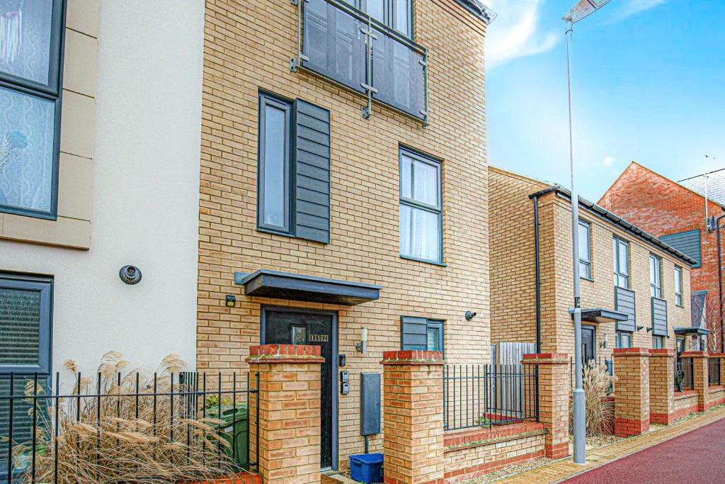 a brick house with black windows on a street at Alpha Properties 1 - Luxury One Bedroom within a Four Bedroom House with Free Parking, Fast Wifi, SmartTV with Netflix in Milton Keynes