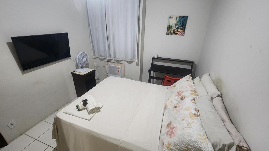 a small room with a bed with a television and a bedskirtspectspectspects at Hostel Hay's 1 Aeroporto Boa Viagem in Recife