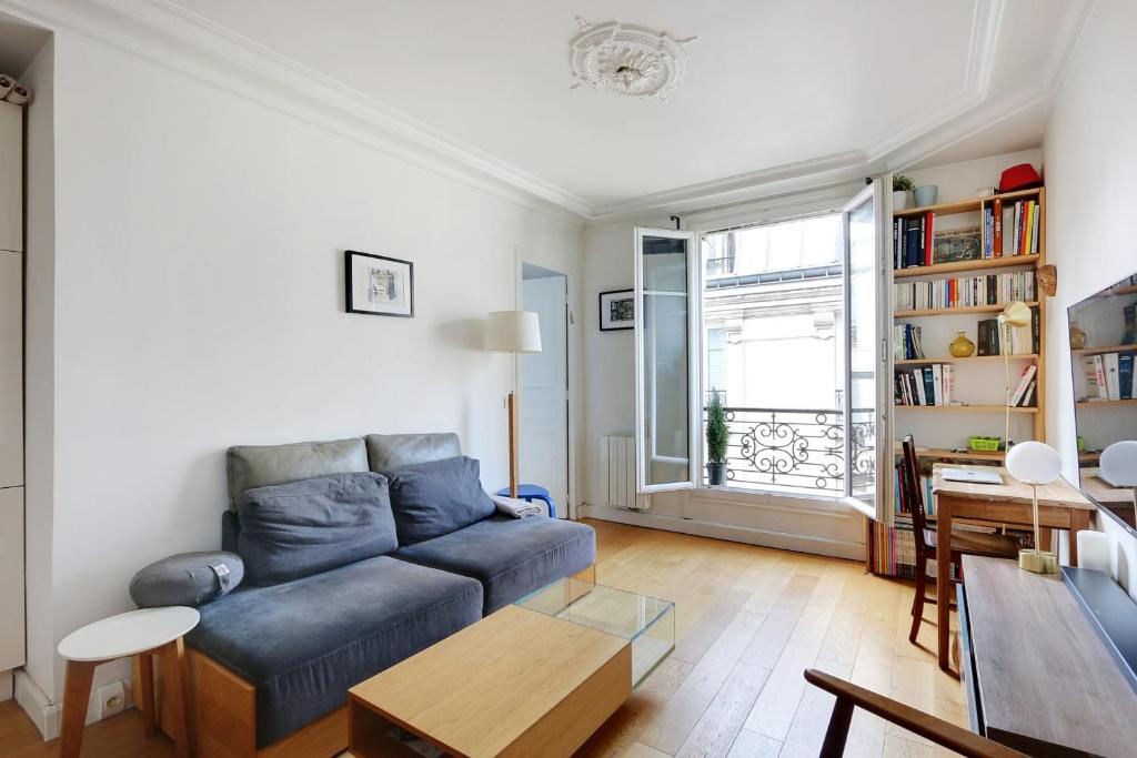 a living room with a blue couch and a table at OBERKAMPF - MENILMONTANT Beatiful appartement for 2 peoples in Paris