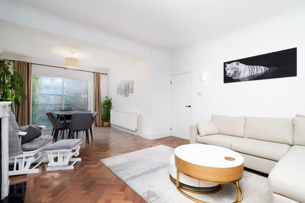 Spacious London Haven for Family and Friends في لندن: غرفة معيشة مع أريكة بيضاء وطاولة