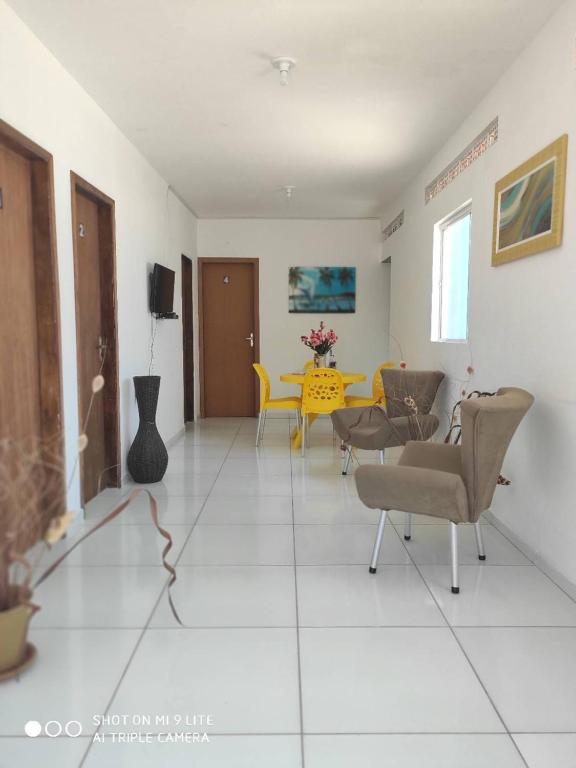 a living room with a yellow table and chairs at Suíte Brilho do Sol in Maragogi
