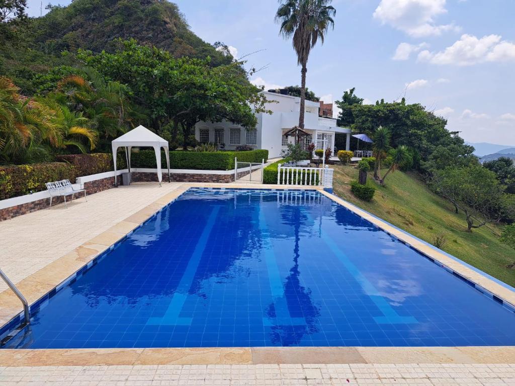 een zwembad met een prieel naast een huis bij LA CASA DE TURRIN in Anapoima
